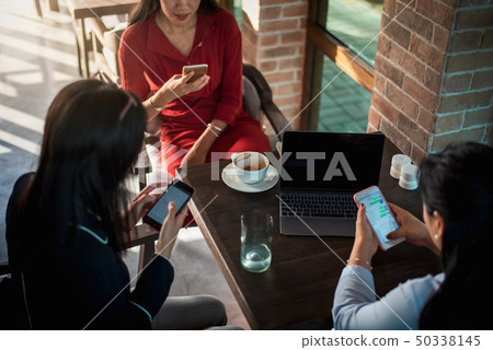 Women using phones in a bar 50338145
