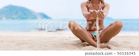 Woman on a white beach with sand in hands at Woman on a white beach with sand in hands at 50338345