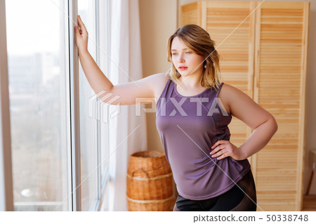 Nice young woman enjoying the view from the window Nice young woman enjoying the view from the window 50338748