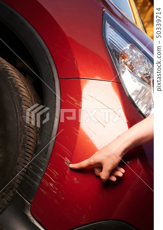 Damaged red car paint on bumper 50339714