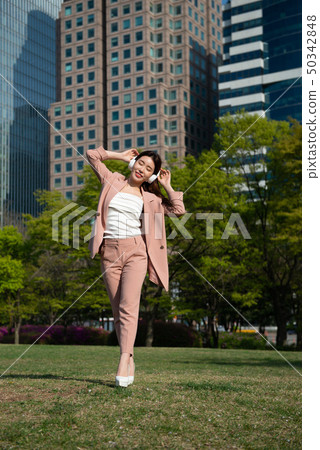 Young woman wearing headphones and enjoying music Young woman wearing headphones and enjoying music 50342848
