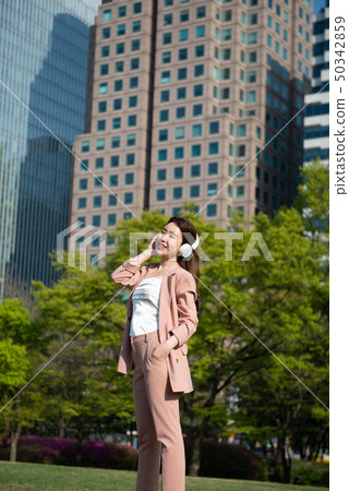 Young woman wearing headphones and enjoying music Young woman wearing headphones and enjoying music 50342859