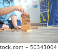 Small kid playing with wooden blocks on the floor 50343004