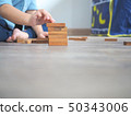 Small kid playing with wooden blocks on the floor 50343006