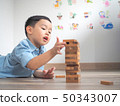 Small kid playing with wooden blocks on the floor 50343007