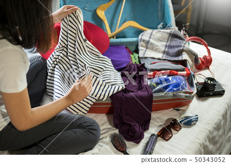 Woman hand packing a luggage for a new journey and Woman hand packing a luggage for a new journey and 50343052
