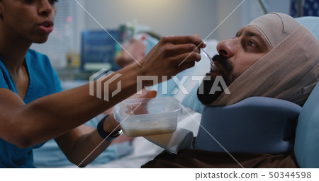 Nurse feeding injured soldiers in hospital bed Nurse feeding injured soldiers in hospital bed 50344598