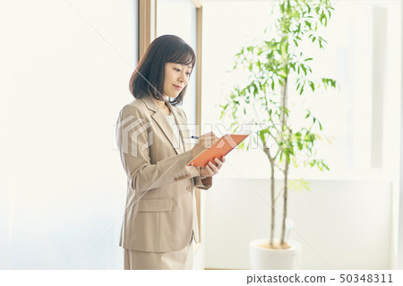 Working woman opening a notebook Working woman opening a notebook 50348311