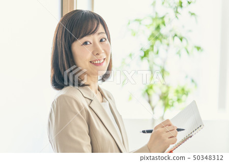Working woman opening a notebook Working woman opening a notebook 50348312