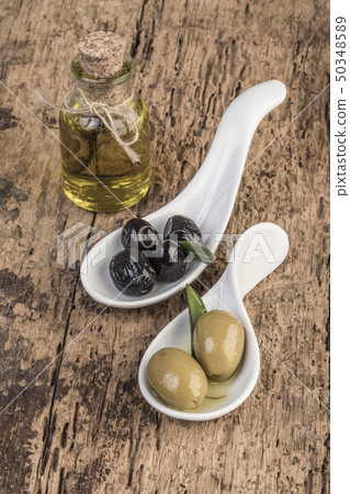 Olives and olive oil on wooden table Olives and olive oil on wooden table 50348589