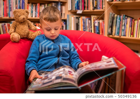 Little boy reading book in a bookstore 50349136
