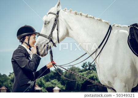 Nice beautiful woman standing in front of her horse Nice beautiful woman standing in front of her horse 50349321