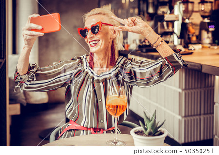 Cheerful short-haired senior lady posing with wide smile 50350251