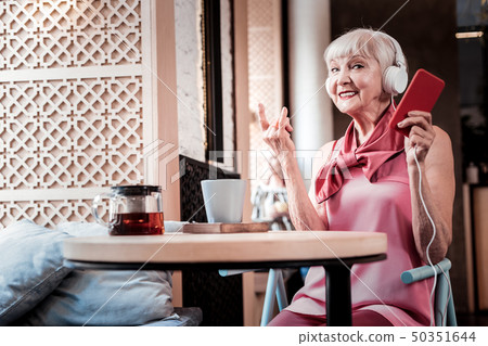 Modern active grey-haired woman in big headphones Modern active grey-haired woman in big headphones 50351644