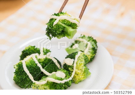 Hand that eats broccoli 50352799