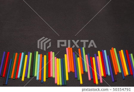 multicolored sticks lay on a black background. multicolored sticks lay on a black background. 50354791