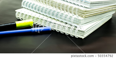 notebooks and two markers on black background. notebooks and two markers on black background. 50354792