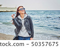 Beautiful young redhead woman staying at the beach 50357675