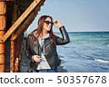 Beautiful young redhead woman staying at the beach 50357678