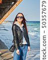 Beautiful young redhead woman staying at the beach 50357679