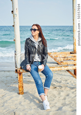 Beautiful young redhead woman sitting near the Beautiful young redhead woman sitting near the 50357694