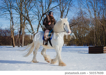 Man in suit of ancient warrior riding big white horse Man in suit of ancient warrior riding big white horse 50357699