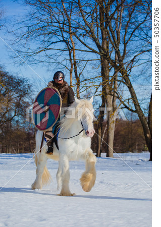 Man in suit of ancient warrior riding big white horse Man in suit of ancient warrior riding big white horse 50357706
