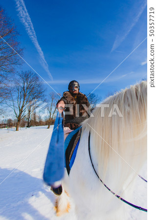 Man in suit of ancient warrior riding big white horse Man in suit of ancient warrior riding big white horse 50357719