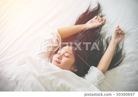 Beautiful young woman sleeping on bed at bedroom Beautiful young woman sleeping on bed at bedroom 50360697