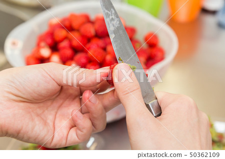 The hand of a woman who cuts strawberries 50362109