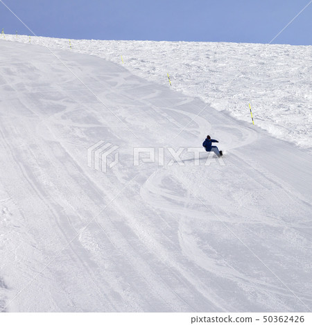 Snowy ski slope and snowboarder at sun day 50362426