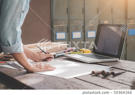 Carpenter working with equipment on wooden table 50364168