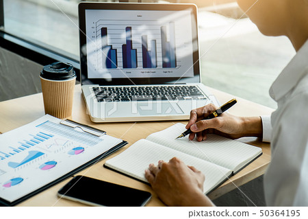 Business adviser analyzing financial figures Business adviser analyzing financial figures 50364195