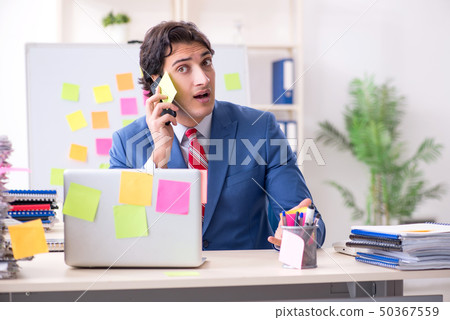 Young male handsome employee in conflicting priorities concept Young male handsome employee in conflicting priorities concept 50367559