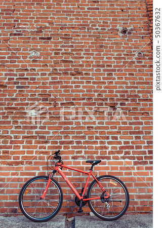 Red bicycle on the background of a brick old wall. Free space for text. The concept of parking and Red bicycle on the background of a brick old wall. Free space for text. The concept of parking and 50367632