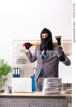 Male gangster stealing information from the office Male gangster stealing information from the office 50372770