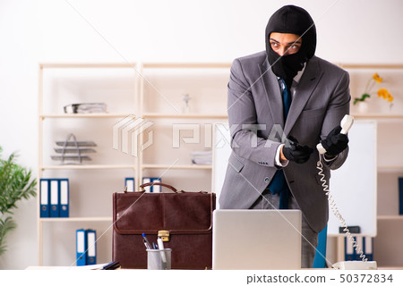 Male gangster stealing information from the office  50372834