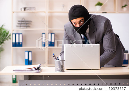 Male gangster stealing information from the office  50372837