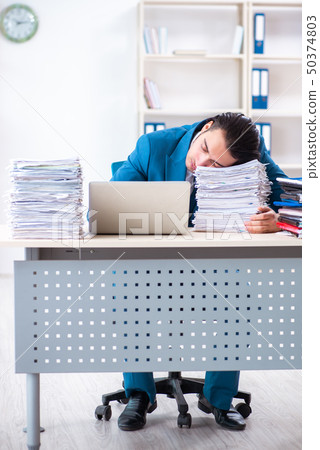 Young male employee unhappy with excessive work  50374803