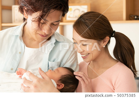 Father holding a baby and mother cuddling 50375385