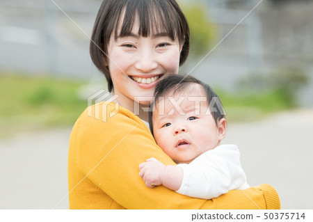 抱著嬰孩日本父母和孩子的一個年輕母親 抱著嬰孩日本父母和孩子的一個年輕母親 50375714