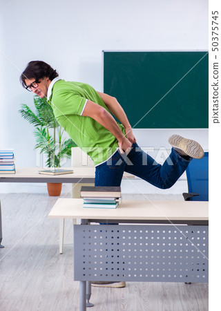 Male student suffering from urge in the classroom   50375745