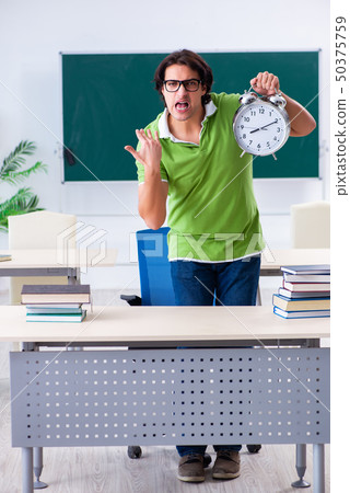 Young male student in front of green board  50375759