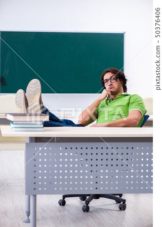 Young male student in front of green board  50376406