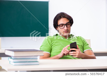Young male student in front of green board Young male student in front of green board 50376417