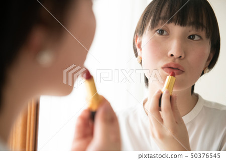 應用唇膏的年輕日本婦女化妝用品秀麗 應用唇膏的年輕日本婦女化妝用品秀麗 50376545