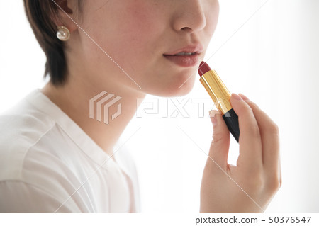 應用唇膏的年輕日本婦女化妝用品秀麗 應用唇膏的年輕日本婦女化妝用品秀麗 50376547