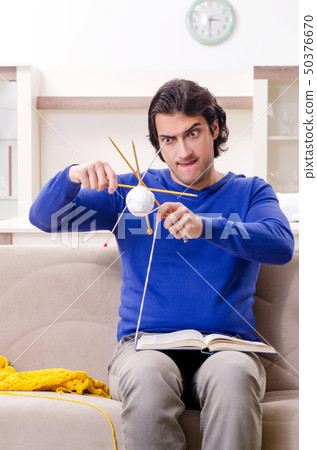 Young good looking man knitting at home 50376670