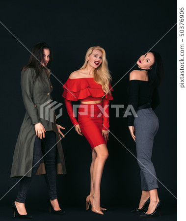 young women friends standing over black background 50376906