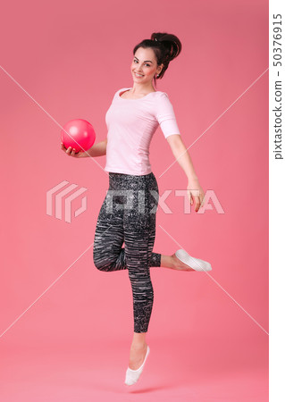 smiling woman jumping with the ball 50376915